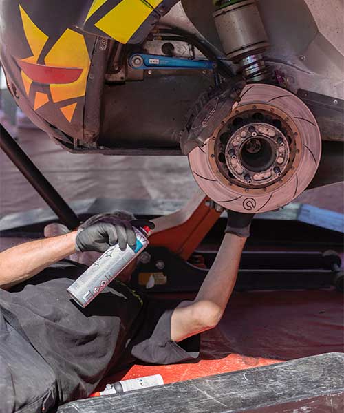 Técnico realizando escaneo OBD2 en el vehículo, con herramienta de diagnóstico en mano.